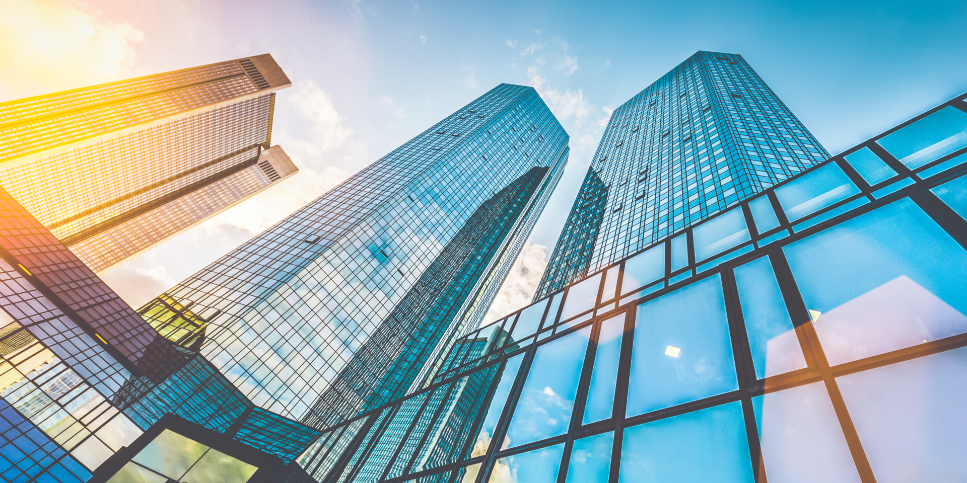 Bottom view of modern skyscrapers in business district in beautiful evening light at sunset with monochrome retro vintage Instagram style filter and lens flare effect