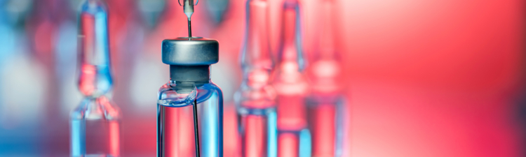 Close up shot of vaccines - glass bottles, ampules and syringe with needle. Good for illustration of flu shot, vaccination and covid-19