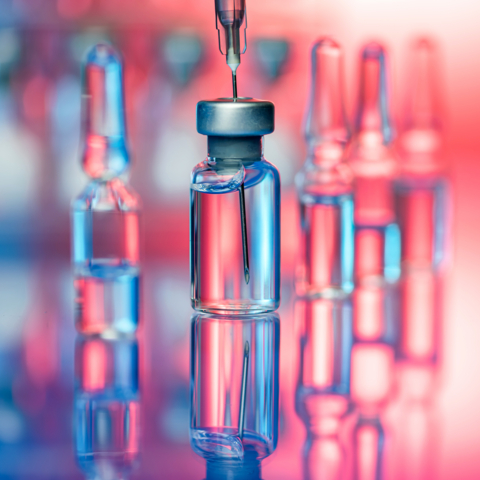 Close up shot of vaccines - glass bottles, ampules and syringe with needle. Good for illustration of flu shot, vaccination and covid-19