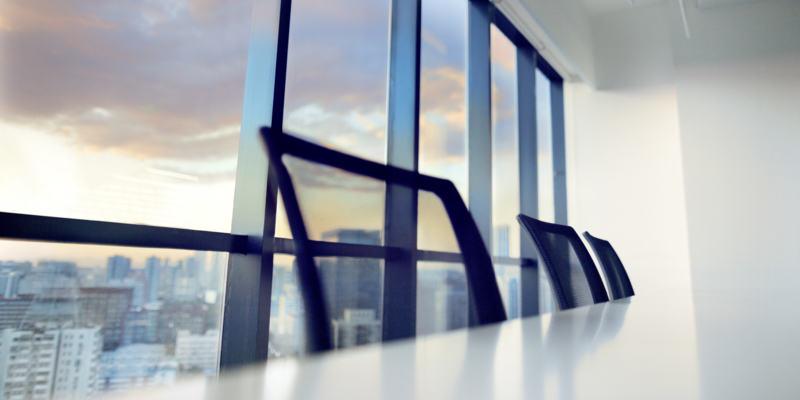 Conference table and chairs in modern office at sunset