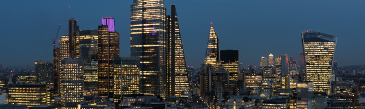 An elevated view of the City of London’s illuminated financial district skyline at night.