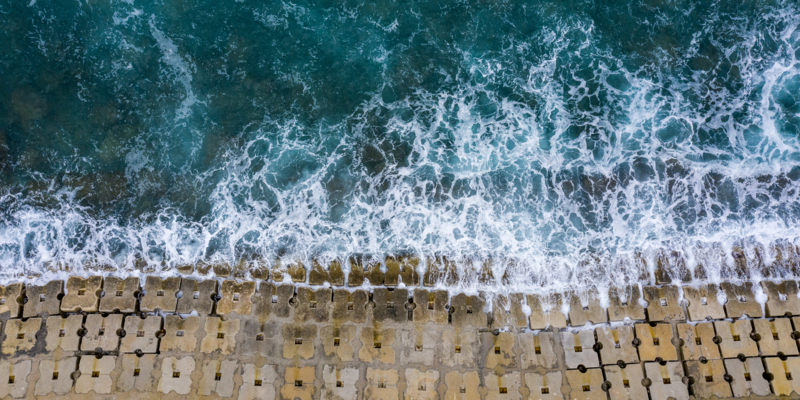 Waves hitting the anti-flood seawall constructed of small concrete cubes.