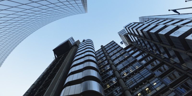 UK, looking up at modern financial buildings in London financial district against clear sky