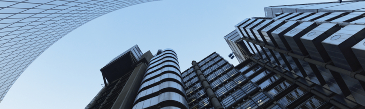 UK, looking up at modern financial buildings in London financial district against clear sky