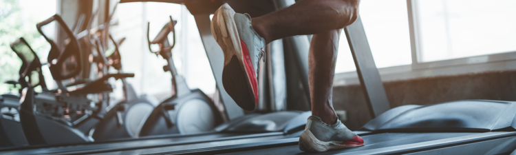 Close up of feet, sportman runner running on treadmill in fitness club. Cardio workout. Healthy lifestyle, guy training in gym. Sport running concept