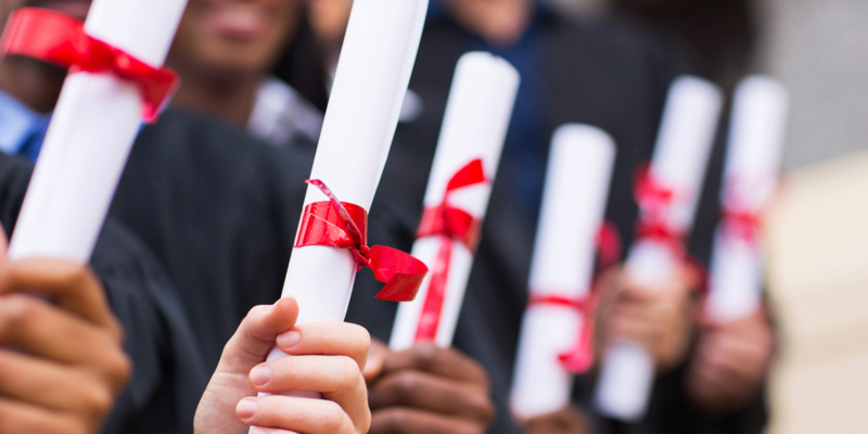 group of multiracial graduates holding diploma