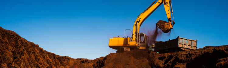 Backhoe machine performing excavation on a site.