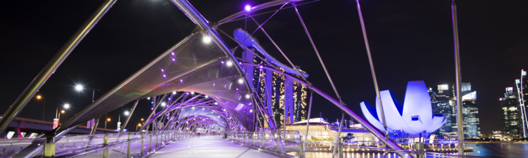 Helix Bridge and the Marina Bay Sands illuminated at night.