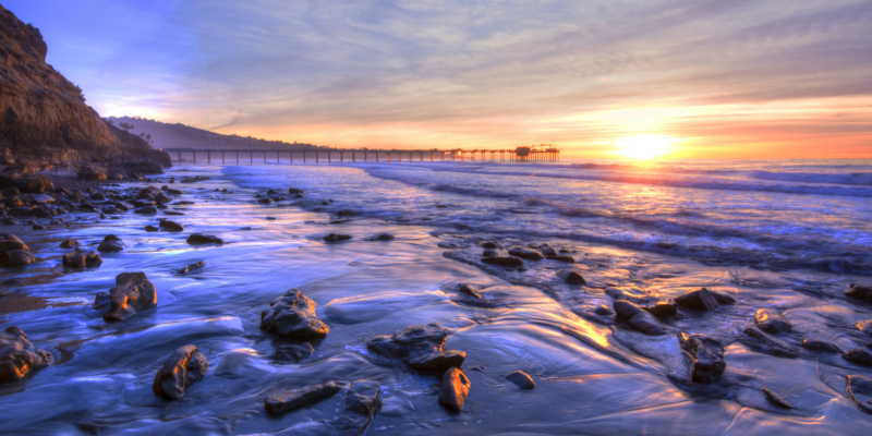 Colorfully vivid scenic southern California beach featuring Scripps pier in La Jolla at sunset with beautiful relfections