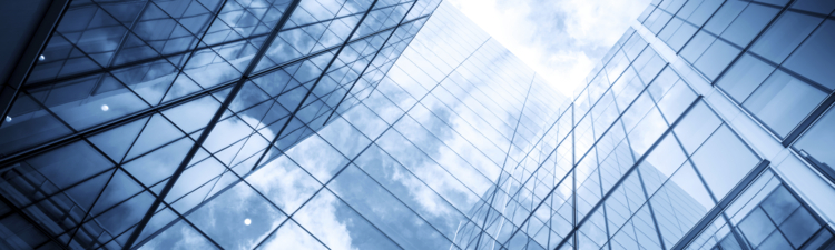 view of a contemporary glass skyscraper reflecting the blue sky and clouds